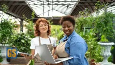 Two young female professionals collaborating on a laptop in a greenhouse for the African Food Fellowship 2026.
